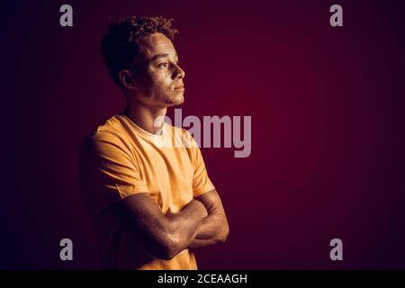 Young adult millennial crossed hand on chest, looking away Stock Photo