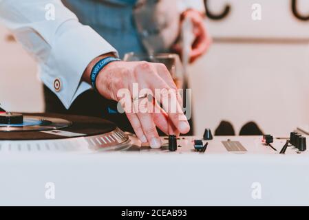 Side view of relaxed bearded male using tablet and enjoying liquor while resting on sofa in elegant pub Stock Photo