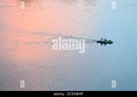 Austin, Texas, USA, Aug. 18, 2020: Paddlers in a bright green kayak enjoy sunset after a hot summer day on Lady Bird Lake in downtown Austin. ©Bob Daemmrich Stock Photo