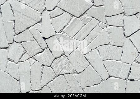 Old gray stone wall painted white with gray paint texture background Stock Photo
