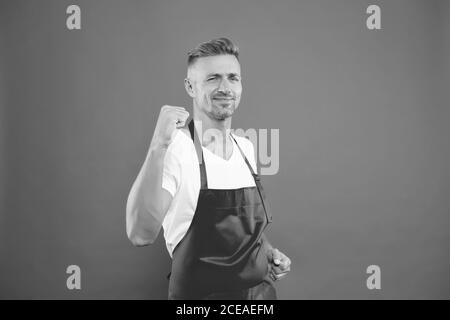 yes, we did it. cheerful mature waiter celebrate success. waiter in a restaurant. he will take the order. best waiter service. handsome waiter in red apron. Successful small business owner. Stock Photo