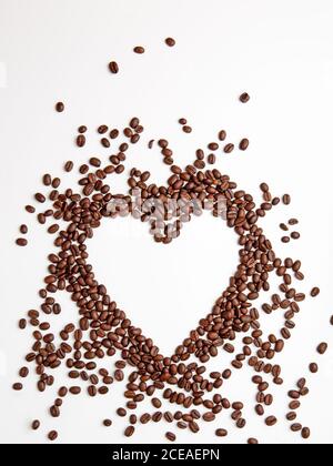 Coffee beans on a white background in the shape of a heart. Stock Photo