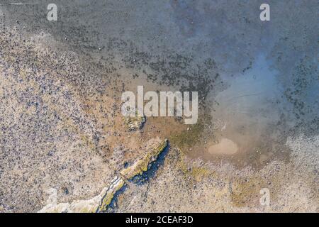Rocky shore at low tide - top down aerial view in United Kingdom Stock Photo