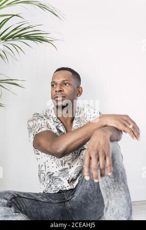 Pensive black man on ground looking away Stock Photo
