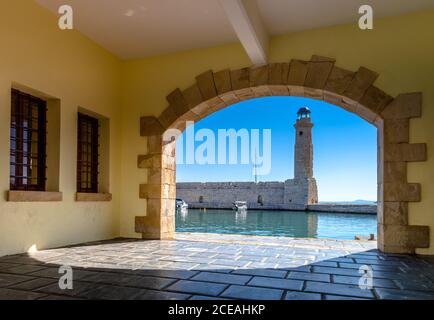 The Egyptian lighthouse at the old harbor of Rethimno through a frame of an arched door, Crete, Greece. Stock Photo