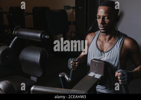 Black man exercising on machine in gym Stock Photo