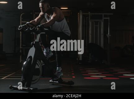 Serious black man on exercise bike in gym Stock Photo