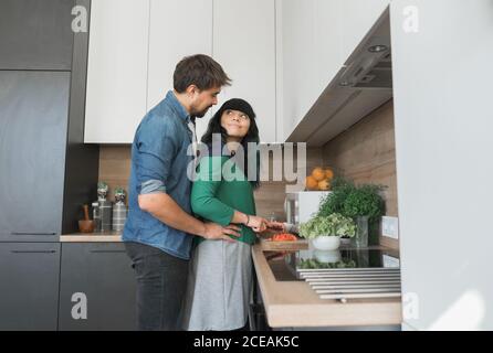 Cheerful couple cooking in kitchen together Stock Photo