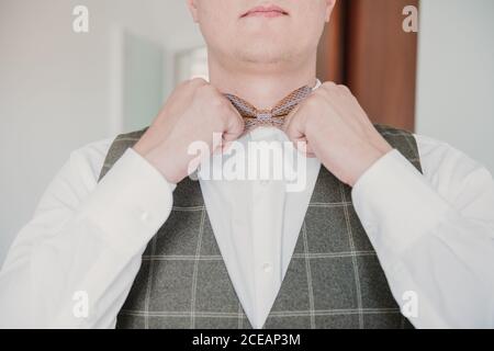 A groom groom adjusting his bow tie Stock Photo