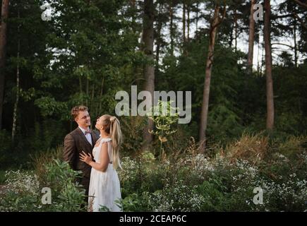 Wedding couple looking each other in the forest Stock Photo