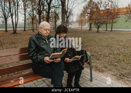 Senior couple reading books in park Stock Photo