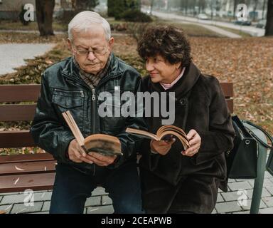 Senior couple reading books in park Stock Photo