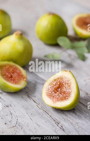 Close-up green unripe fig fruit on wooden table. Stock Photo