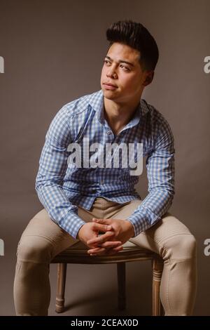 Handsome male posing on chair Stock Photo