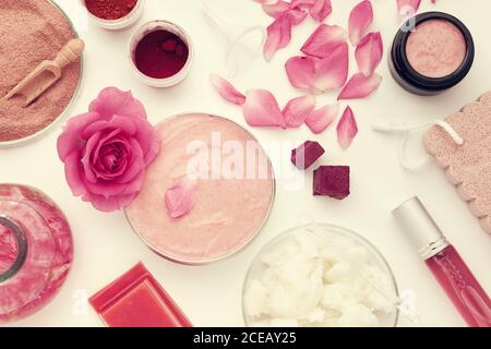Jar with a homemade moisturizing beauty cream, rose flower, infused water or oil, coconut oil, rose blend or flavored water in a spray bottle, hydroly Stock Photo