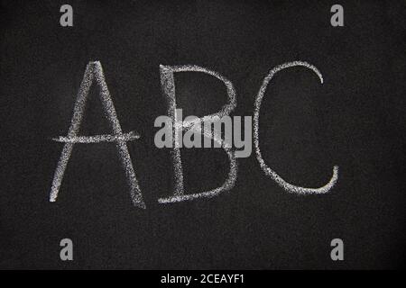 the letters A, B, C isolated on black, closeup of first english alphabet letters written on a blackboard with a piece of chalk Stock Photo