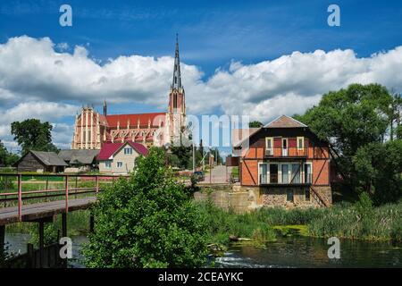 Retro water mill and old church of the Holy Trinity in Gerviaty on background, Grodno region, Belarus Stock Photo