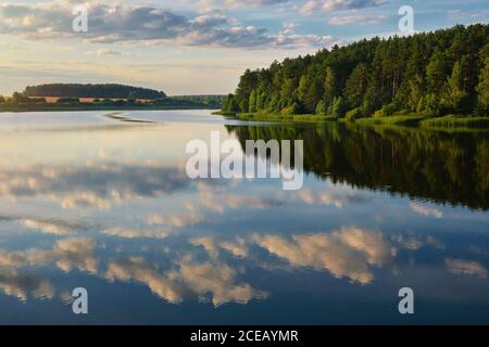 Beautiful tranquil lake with cloud reflection. Reservoir Petrovichi on the Volma river, Minsk region, Belarus.