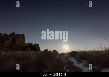 Full moon rising over the hill on a winter night Stock Photo