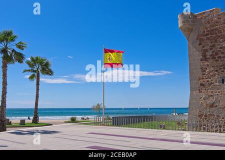 Old brick wall standing behind fence near nice beach in wonderful Spain. Stock Photo