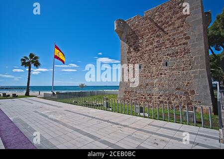 Old brick wall standing behind fence near nice beach in wonderful Spain. Stock Photo