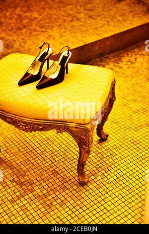 High heel shoes on parquet near chair Stock Photo