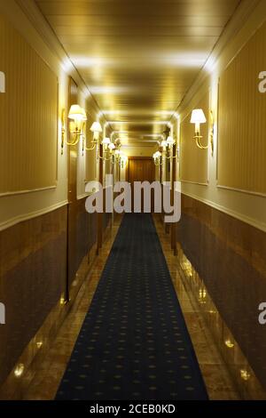 Hotel hall lit by lamps on walls Stock Photo