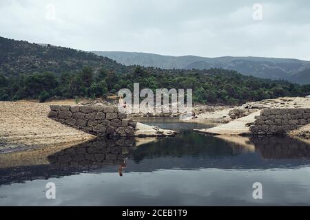 Young Woman sitting on rock near water Stock Photo