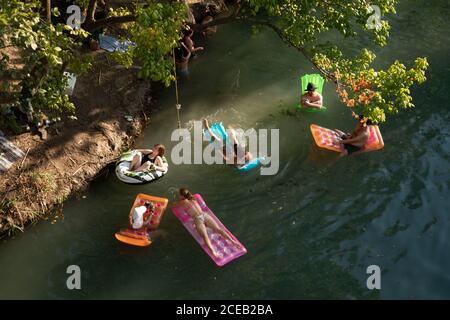Young people eager to get outdoors during the coronavirus pandemic find a quiet spot to float in the cool waters of Barton Creek south of downtown Austin on a hot summer Sunday. ©Bob Daemmrich Stock Photo