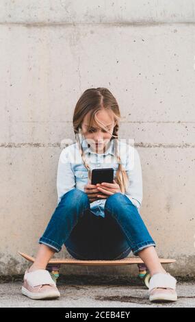 Kid using mobile phone with skate Stock Photo