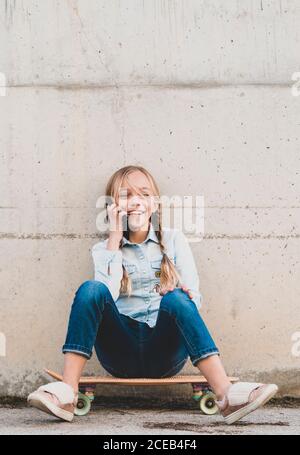 Kid using mobile phone with skate Stock Photo
