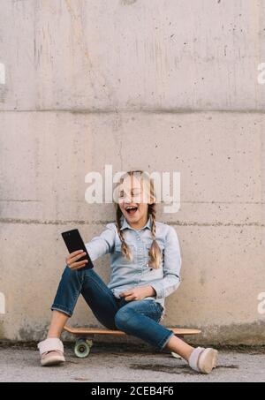 Kid using mobile phone with skate Stock Photo