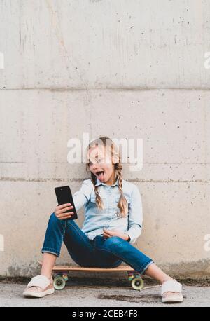 Kid using mobile phone with skate Stock Photo