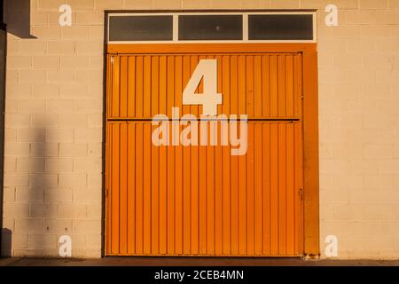 Stripped colored entry on sunlight with white bricks wall and small windows Stock Photo