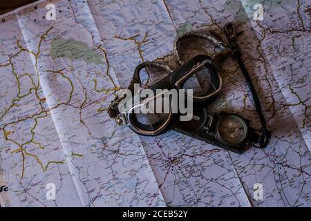 planning a trip on a map with vintage motorcycle glasses and compass Stock Photo