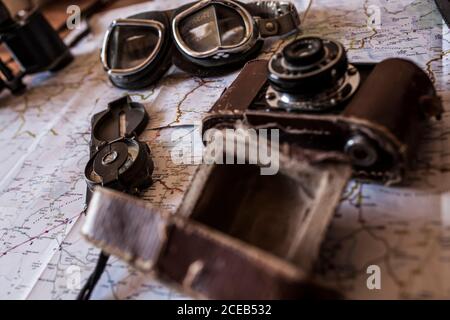 planning a trip on a map with vintage motorcycle glasses, old photo camera and compass Stock Photo