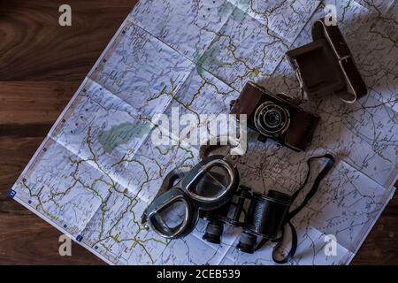 planning a trip on a map with vintage motorcycle glasses, old photo camera, prismatic and compass Stock Photo