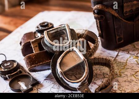 planning a trip on a map with vintage motorcycle glasses, old photo camera, prismatic and compass Stock Photo