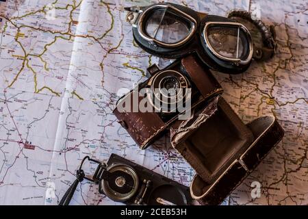 planning a trip on a map with vintage motorcycle glasses, old photo camera and compass Stock Photo