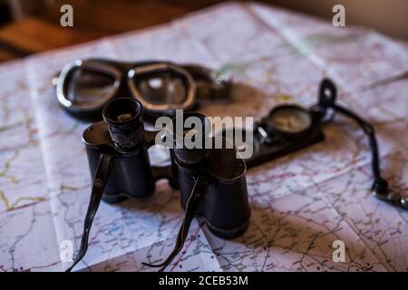 planning a trip on a map with vintage motorcycle glasses, old photo camera, prismatic and compass Stock Photo
