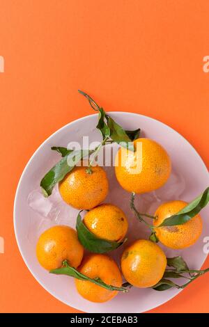 Fresh tangerines in season. Flat lay. Top view On orange background Stock Photo