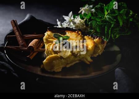Apple pie with cinnamon and mint on dark background. Homemade Stock Photo