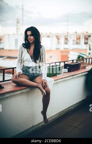 Young Woman sitting at balcony and smiling Stock Photo