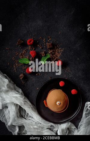 Chocolate with red chilli peppers, mint and raspberries on dark background.Flat lay- Cake Stock Photo