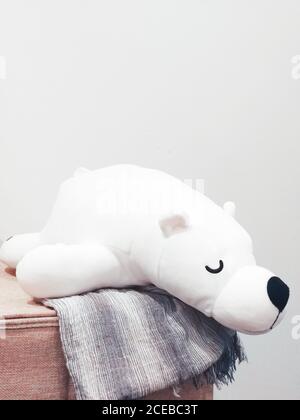 Cute and sleepy teddy laying on soft leather at the corner. Stock Photo