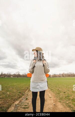 An attractive young woman in a straw hat and summer dress posing with ...