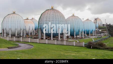 Big sphere reservoirs placed in industrial area of Gijon in Spain and separated with fence on green grass Stock Photo