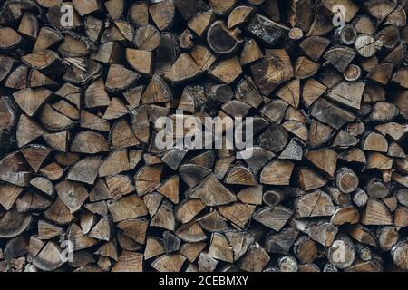 Beautiful background of ends of cut and chopped small firewood logs stacked in pile Stock Photo
