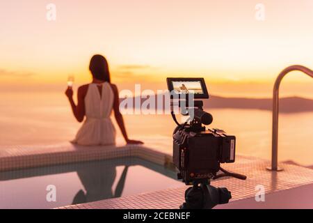 Video camera filming actress woman acting for movie on luxury hotel location behind the scenes of shoot. Professional videography equipment shooting Stock Photo