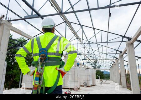 Asian senior engineer technician construction wearing safety harness and safety line working in construction site Stock Photo